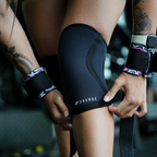 Person wearing a black knee brace with 'Savage' branding, holding a strap.