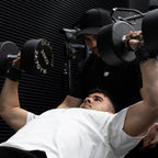 Person lifting weights with a personal trainer in a gym setting